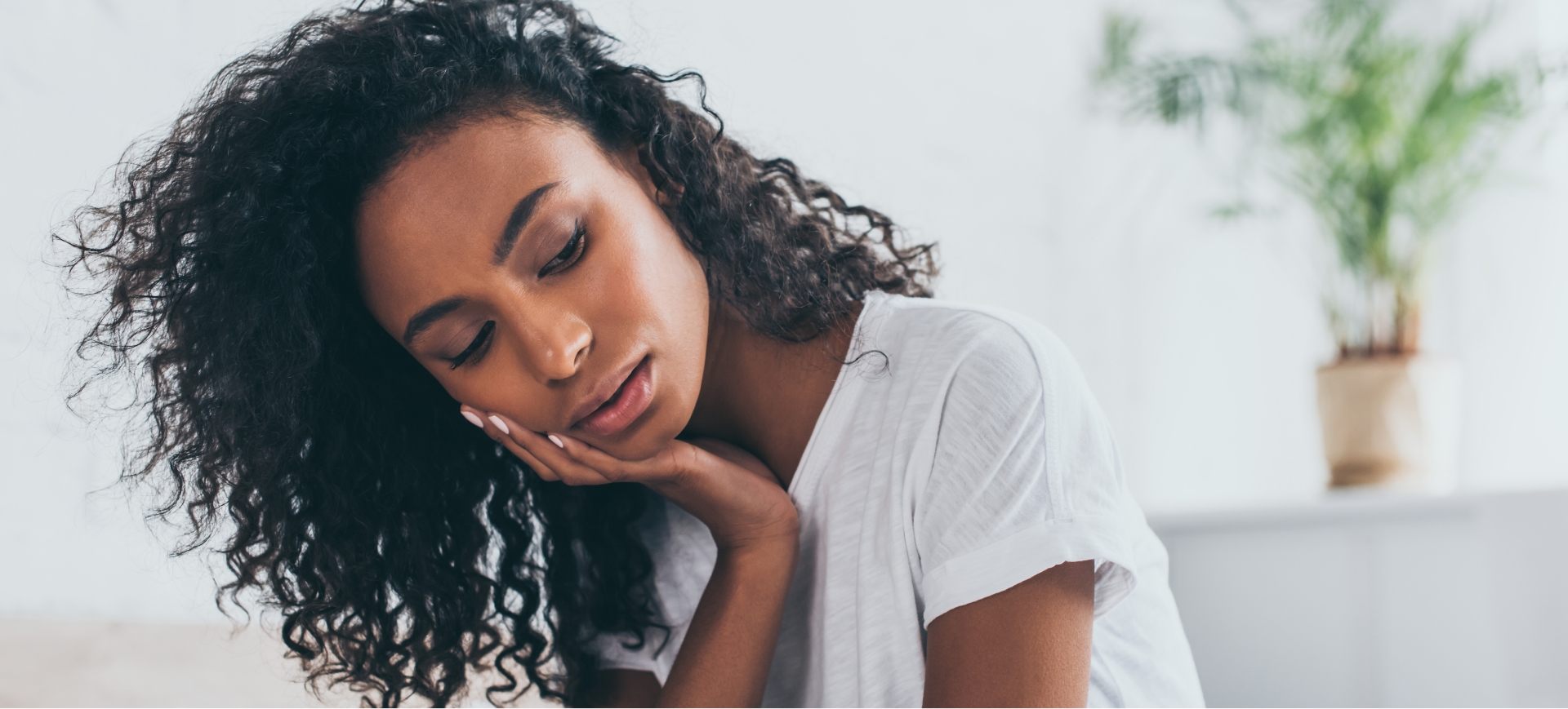 Woman holding her cheek in pain before emergency dentistry in Colorado Springs