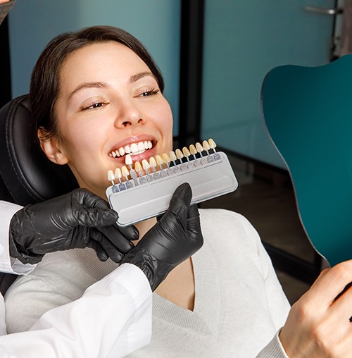a patient examining her smile in a mirror