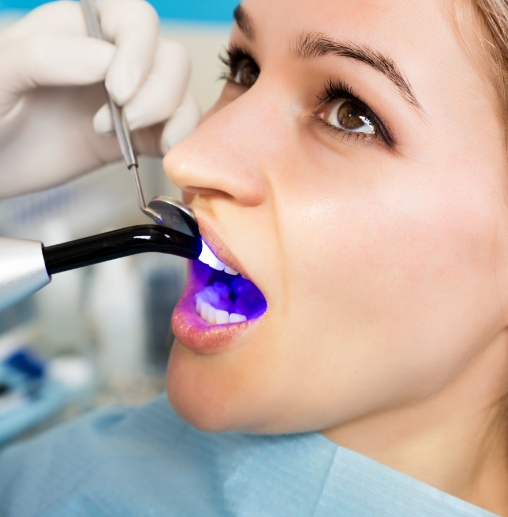 Dental patient receiving cosmetic bonding on upper front tooth
