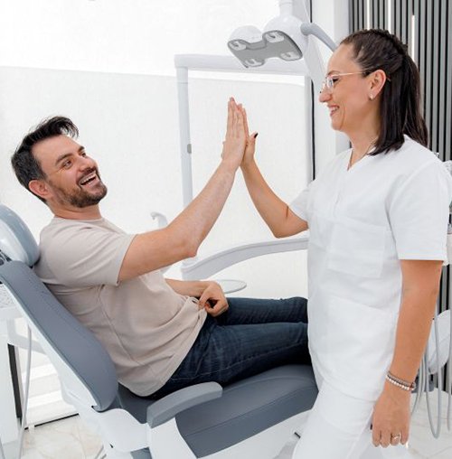 Patient high-fiving dental team member