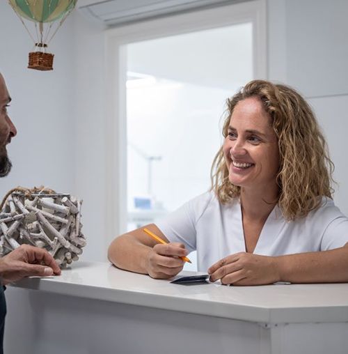 Patient and dental team member interacting at front desk