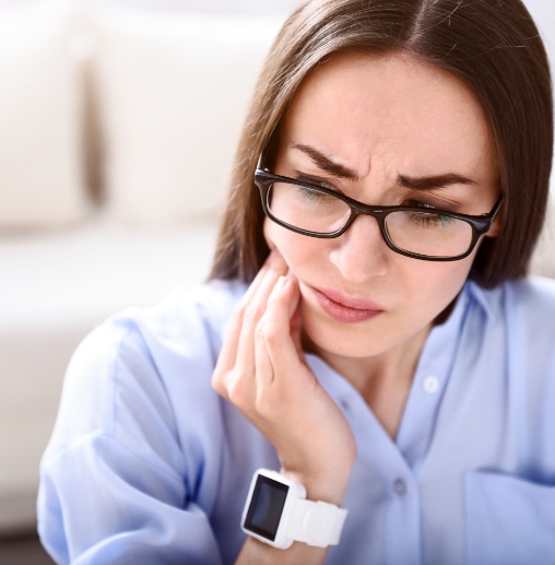 Woman holding the side of her jaw in pain before T M J treatment in Colorado Springs