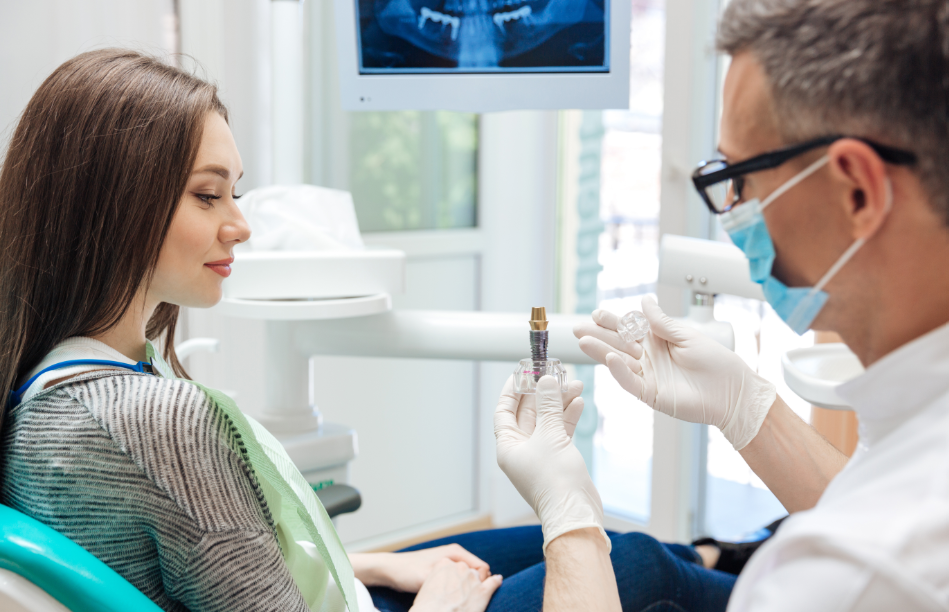 Dentist showing patient dental implant